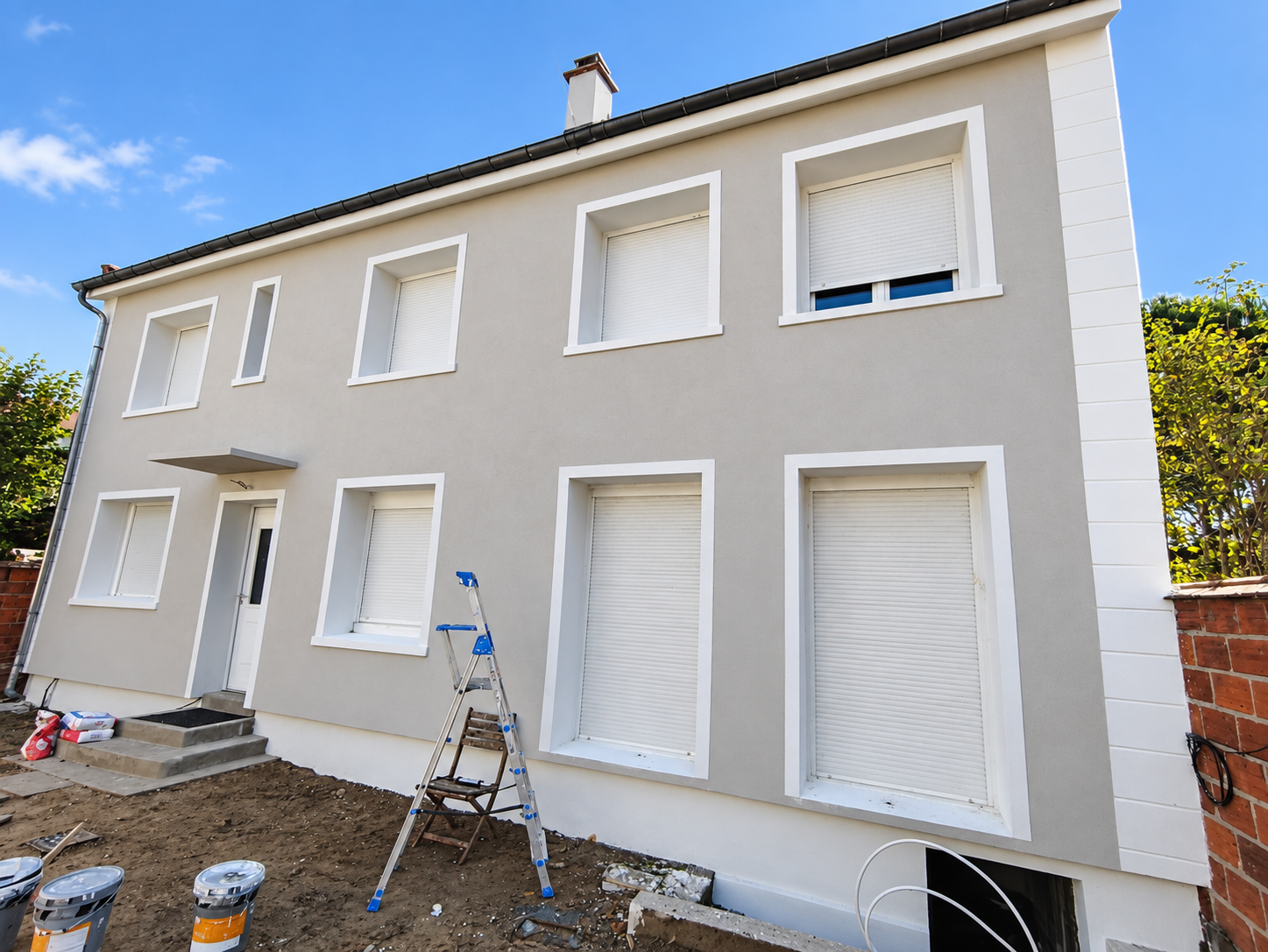 Façade rénovée de couleur grise avec encadrements blancs